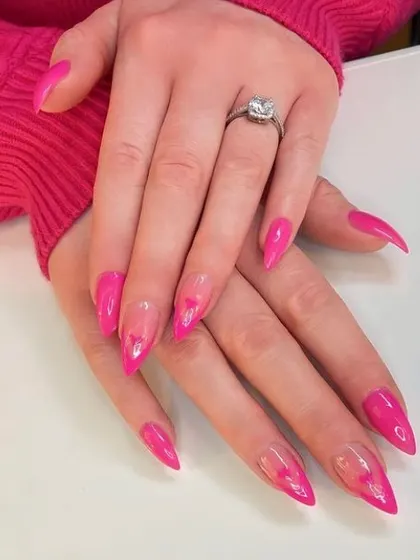 A bold and playful design with stiletto nails, featuring a sheer base with hot pink jelly hearts for a fun, see-through effect.