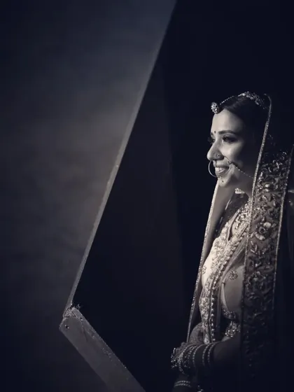 A beautiful black and white profile portrait of a bride. The soft lighting and her gentle smile create a timeless and classic feel.