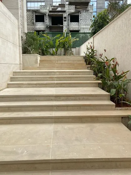 We handle all hardscaping, including the construction of these wide, elegant stone staircases that connect different levels of the property.