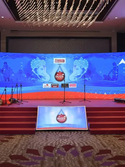 The stage for a corporate seminar, featuring a large, curved LED screen with clear branding and professional lecterns. The setup is clean, modern, and designed for effective communication.