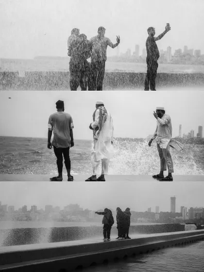 A black and white photo series capturing the spirit of Mumbai's monsoon at Marine Drive. People are seen enjoying the high tide, getting drenched by waves, and finding joy in the downpour.