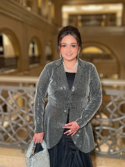 Posing with her shimmering handbag, she is ready for a glamorous night out. The makeup is designed to last all evening.