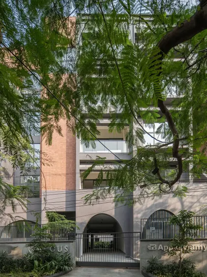 Street-level views of ARCUS, showing how the building integrates into its urban context, with mature trees providing a natural screen and a lively street scene in the foreground.