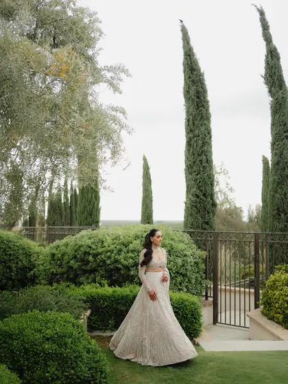 A wide shot of the bride in her stunning Gaurav Gupta gown, set against the manicured gardens of a California estate. This is a perfect editorial bridal portrait.