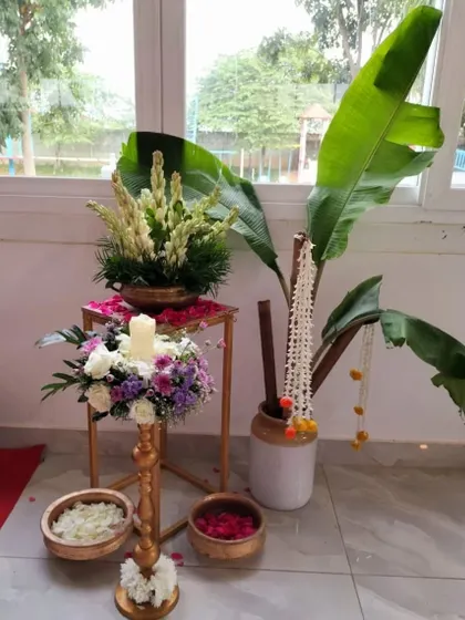 A traditional welcome setup for a South Indian wedding, featuring a brass lamp, banana leaves, and fresh floral arrangements.
