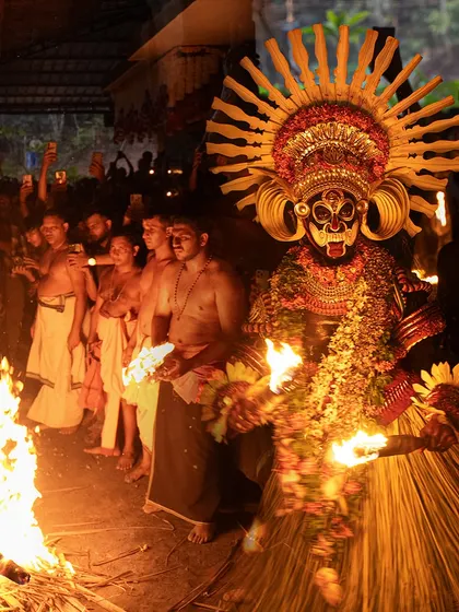 A series showing the Karim Gullikan Theyyam performance, surrounded by devotees and fire. These images document the energy of the crowd and the deity's commanding presence during the ritual.