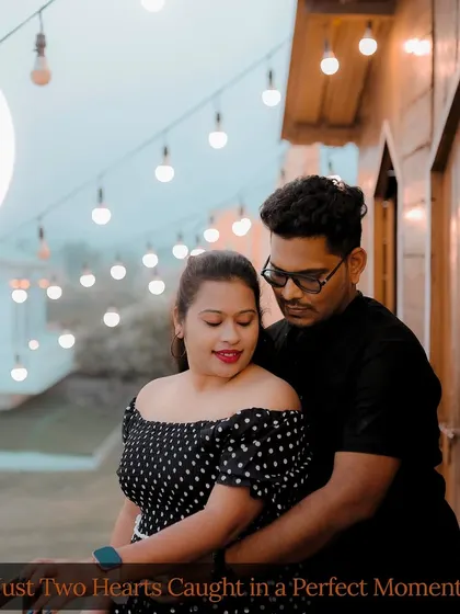 An intimate moment on a balcony set, with soft string lights creating a warm and romantic ambiance for this pre-wedding portrait.