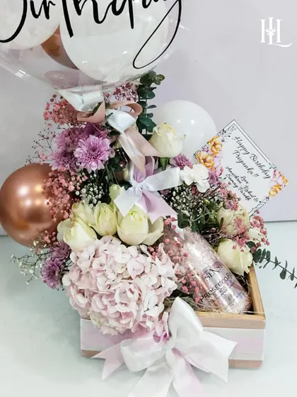 This luxury birthday hamper is all about making a statement. It combines a beautiful floral arrangement with a bottle of sparkling drink and a custom balloon, presented in a high-quality box for an unforgettable celebration.