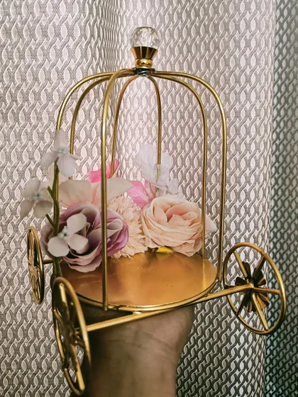A decorative golden carriage, perfect for holding smaller, precious gifts or as a standalone decorative piece in a trousseau.
