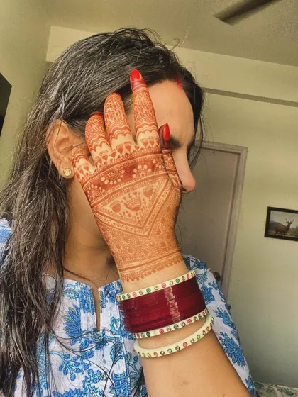 A client showing off the gorgeous, deep orange stain of her Karvachauth mehndi. This is the beautiful color you can expect as the henna matures.