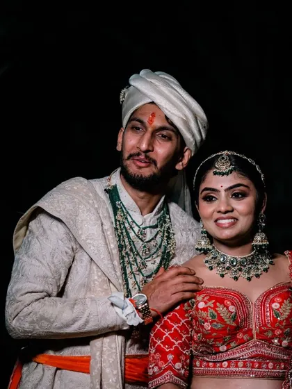 A handsome North Indian groom in his sherwani and turban, posing with his beautiful bride.