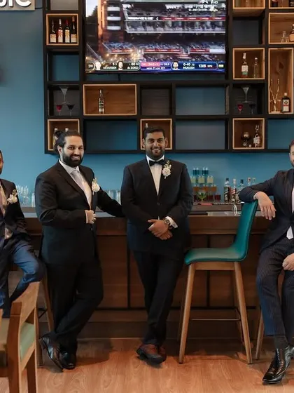 A cool, relaxed group portrait of the groom and groomsmen at the bar before the ceremony.