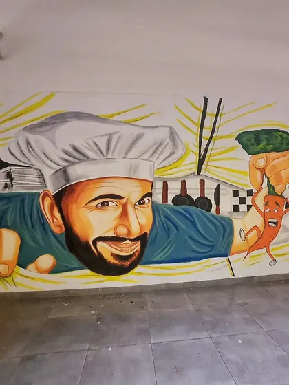 On another wall in the Novel Office cafeteria, we painted this giant, friendly chef presenting his ingredients.