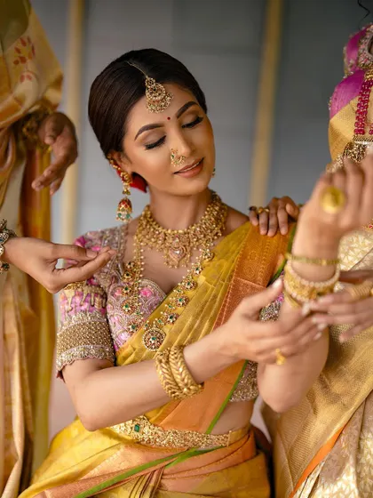 A beautiful candid moment of a bride getting ready, with her bridesmaids helping her with her jewelry. This shot captures the intimacy and excitement of the pre-ceremony moments.