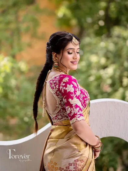 A beautiful shot showcasing the back of this custom pink blouse. The intricate bird and floral embroidery adds a whimsical and personal touch to the bride's pre-wedding outfit.
