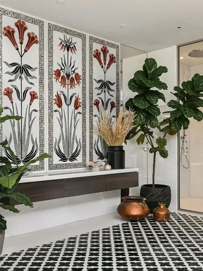 This home spa features a magnificent wall panel with floral motifs created using mother-of-pearl and stone inlays. This intricate artwork, combined with the geometric floor tiles and abundant greenery, creates a space that is both opulent and calming.