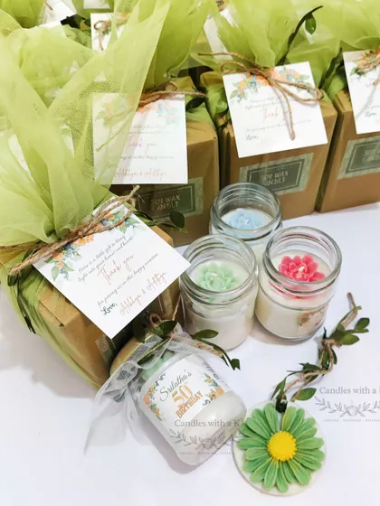 A close-up of the 50th birthday gift set, showing the personalized candle and daisy sachet.