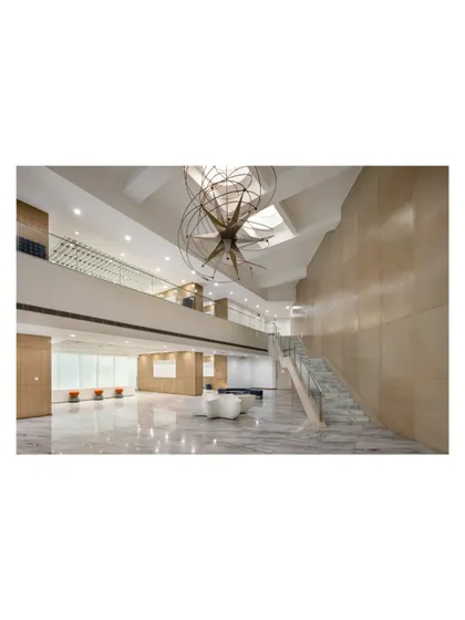 A wide view of the same lobby, showing how the staircase connects levels while defining the scale and proportion of the entrance hall. Its tectonics and detailing carry the architectural language of the entire building.