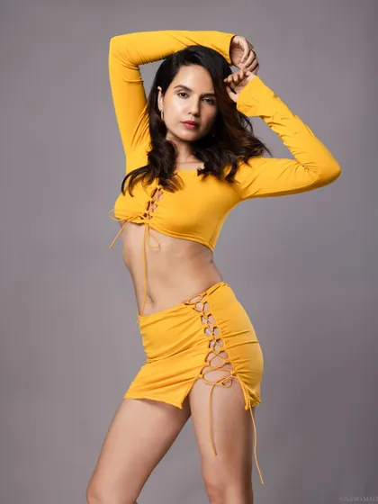 A model in a yellow outfit, with a graceful and dynamic pose.