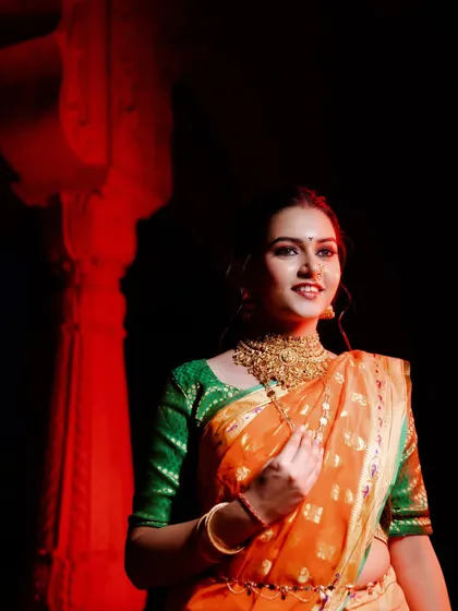 A stunning solo portrait of the bride-to-be in her traditional Paithani saree. I use focused lighting to accentuate the intricate jewelry and the radiant glow of anticipation.