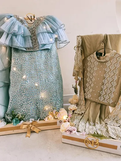 Two stunning outfits displayed on custom stands as part of a wedding trousseau. This presentation style is perfect for showcasing the bride's most important ensembles.