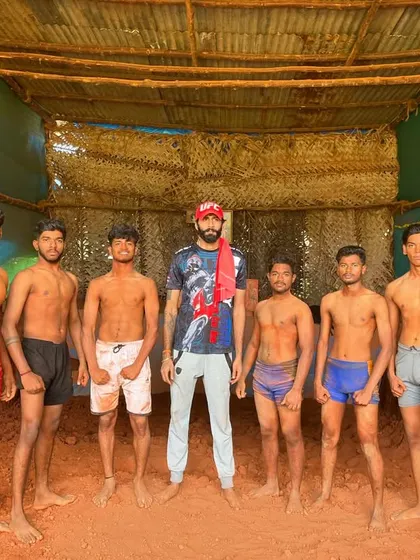 My team of wrestlers (Pailwans) standing in our traditional akhara (mud pit) after a hard training session.