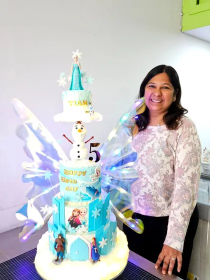 Me with a massive, fairy-winged Frozen-themed cake. The smile says it all!