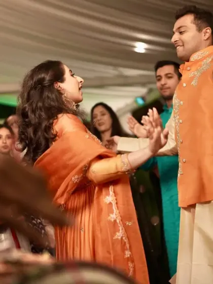 The couple dancing with joy during their Behrano ceremony, surrounded by family and friends.