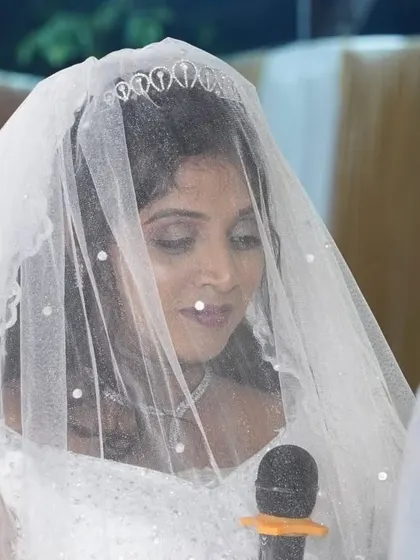 A serene moment during the ceremony. The delicate veil adds a touch of romance, and her makeup is soft and subtle underneath.