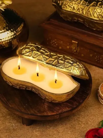 The lit peanut-shaped urli candle, creating a warm and inviting ambiance.