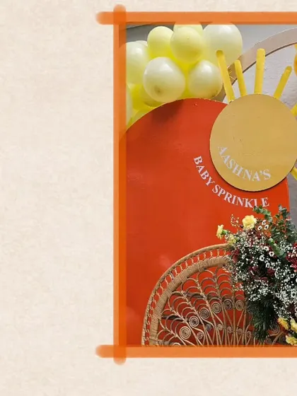 A close-up of the custom 'Baby Sprinkle' sign, designed to look like a shining sun.