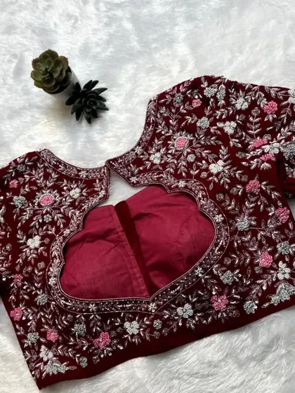 The back of the red velvet blouse, featuring a heart-shaped cutout surrounded by dense floral embroidery.