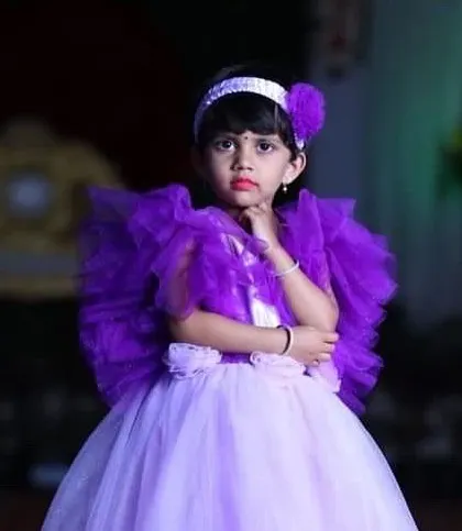 Two sisters in matching lavender and purple gowns with dramatic tulle shrugs for a birthday party.