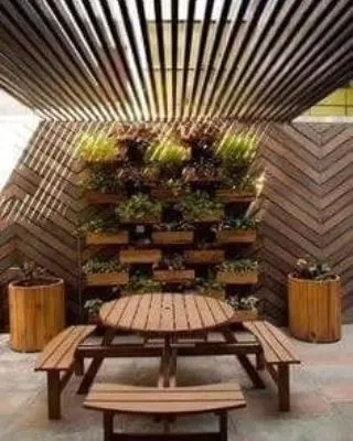 Our expertise extends to creating complete outdoor environments. This setup features our wooden picnic table and benches, complemented by large planters and a vertical garden wall, demonstrating how we can transform a space into a green, functional oasis.