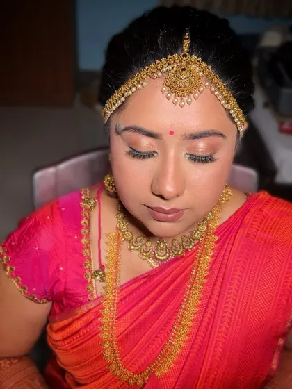A classic South Indian bridal portrait. The makeup is centered around defined, yet soft eyes and a flawless base, allowing the magnificent temple jewellery and silk saree to take center stage.