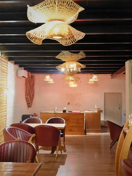 The warm and inviting ambiance of our indoor cafe, with its wooden floors and artistic light fixtures.