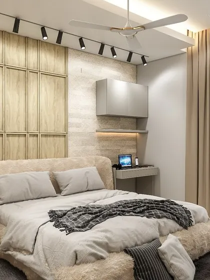 Another angle of the multi-functional bedroom, showing the compact study or work-from-home nook next to the bed. The track lighting on the ceiling ensures the entire space is well-lit.