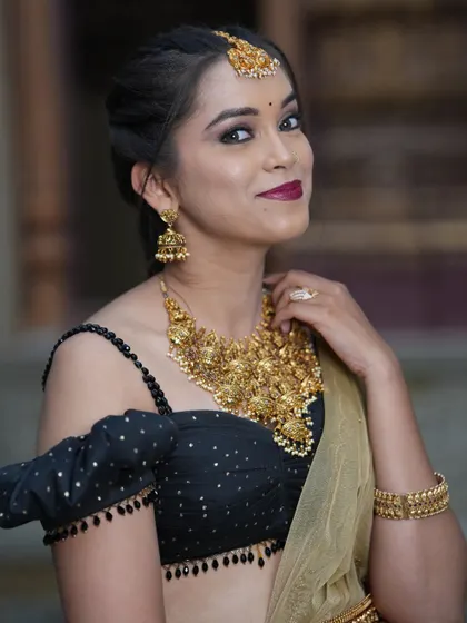 A student portfolio shoot featuring our black off-shoulder blouse paired with a simple gold saree, showing the versatility of our pieces.