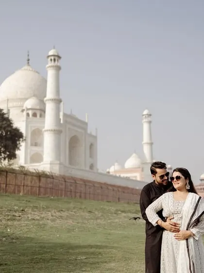A candid moment by the riverbank, with the Taj Mahal in the distance. This shows a different, more rustic side of the location, adding variety to your Agra pre-wedding album.