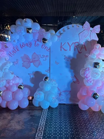 The complete photo booth setup for the "Half way to one" party, with soft blue lighting enhancing the pink and white decor.