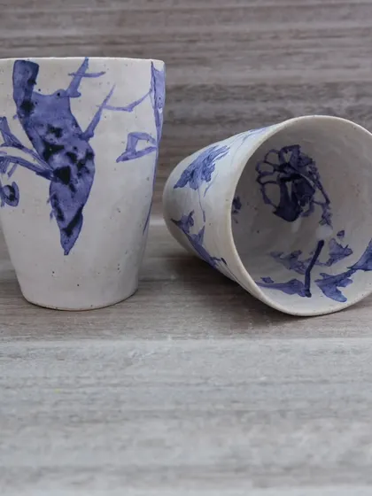 Another view of the hand-painted glasses, showing different floral and bird-like motifs. The beauty is in the imperfection and the free-flowing brushwork.