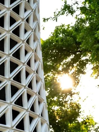 Sunlight catches the edge of the tower's facade, creating a dynamic interplay of light and shadow.