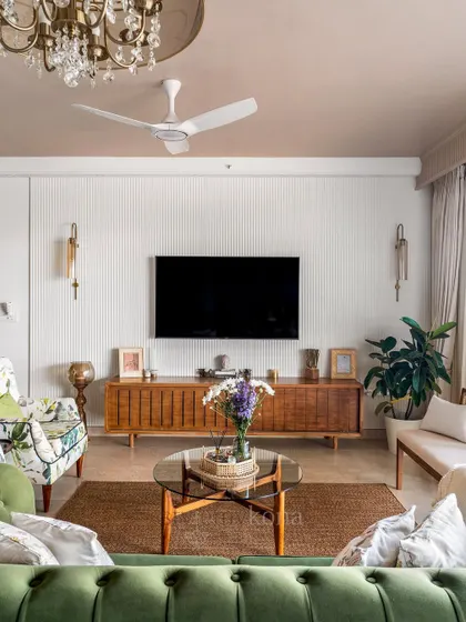 A straight-on view of the TV wall, featuring simple white fluting and a warm wooden console. The design is clean, uncluttered, and functional.