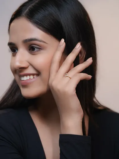 A commercial shoot for a diamond jewelry brand. The focus is on the hand and the elegant ring, with the model's happy expression in the background.
