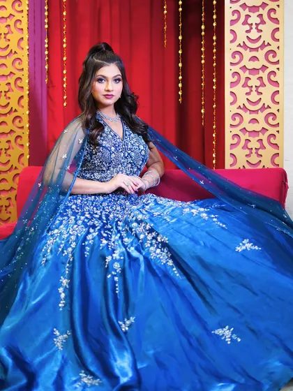 Another seated pose in the blue ball gown, perfect for capturing a regal look.