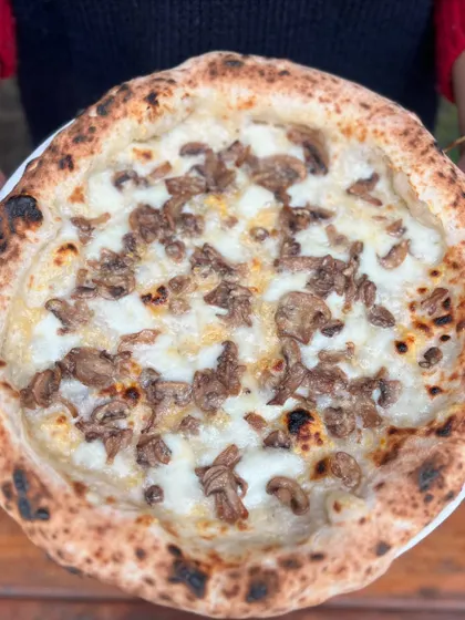 Holding up the Pizza Bianca. It's a unique and flavourful choice.