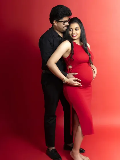 A bold and vibrant maternity portrait using a solid red backdrop. The color adds a touch of passion and excitement to this special time in a couple's life.