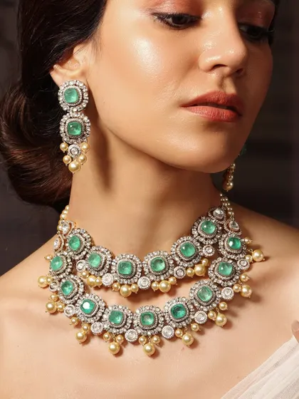 A classic double-strand necklace from the Emrosia collection, featuring round emeralds and polki diamonds, finished with pearl drops.
