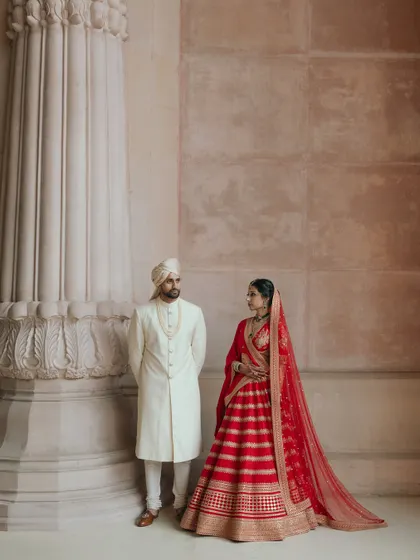 A regal portrait of Avin and Nikki at The Leela Palace. The grand architecture and their classic pose create an image of timeless elegance.