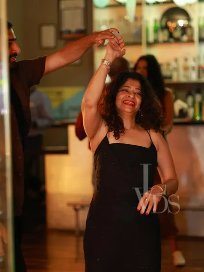 A happy couple enjoying a dance, the woman's smile lighting up the frame. It's all about joy and connection.